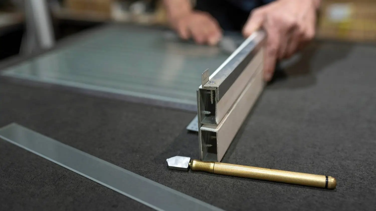 Skilled glazier using precision tools to cut glass for a unique custom project in Altona North