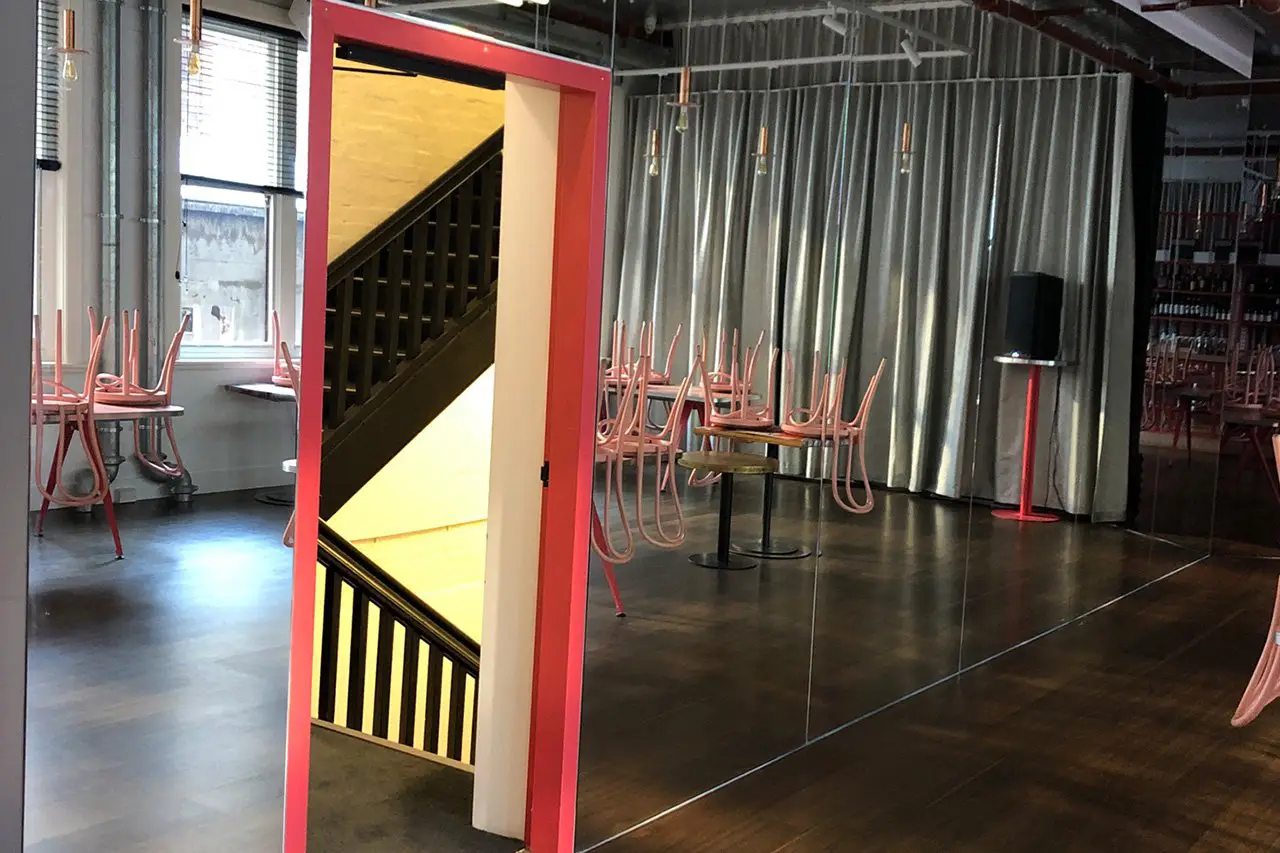 Frameless sliding glass door opening to a patio in a Brooklyn home 