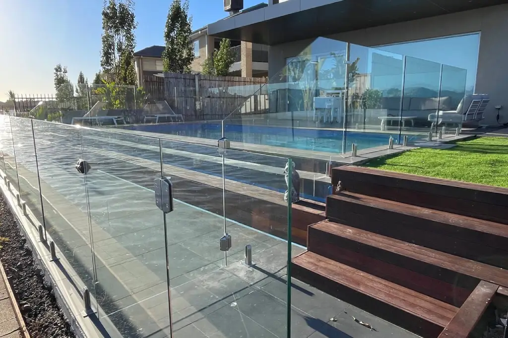 Frameless glass pool fencing installed around a stylish backyard pool in Newport