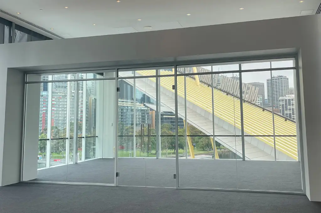 Frameless glass doors and walls offering clear city views from a modern Newport property 