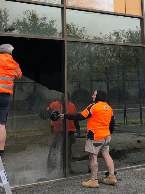 Commercial glaziers at work fitting glass panels in a modern commercial building in Melbourne