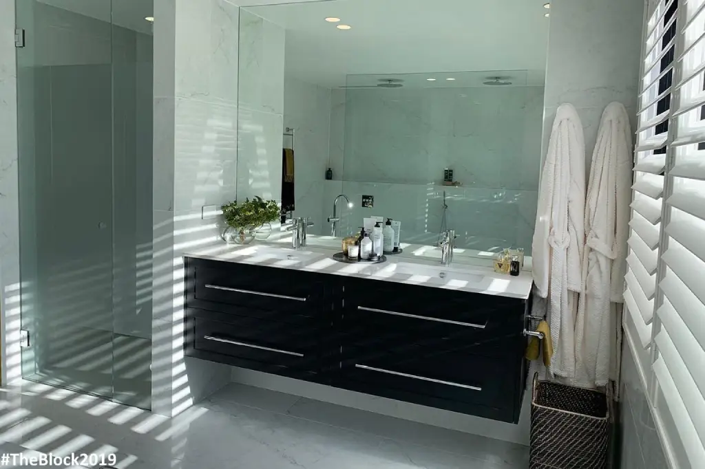 Sleek custom mirror above a bathroom vanity in a modern bathroom