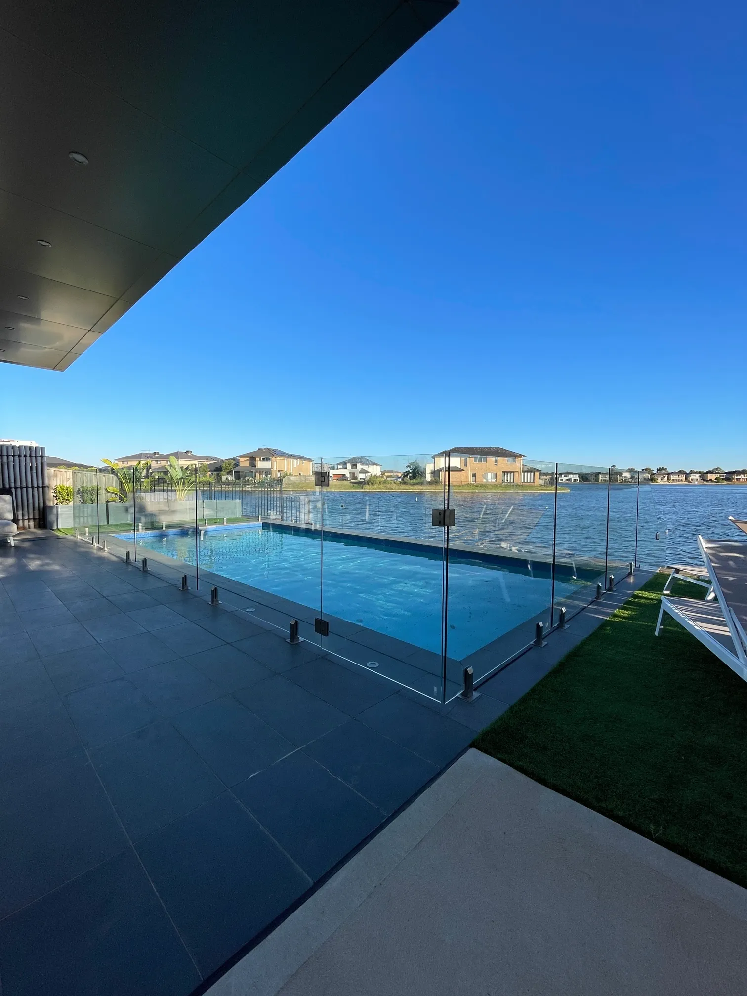 Clear glass fence offering safety and visibility around an outdoor swimming pool