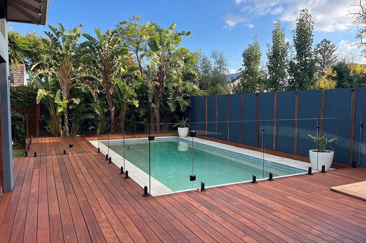 Frameless glass pool fence surrounding a landscaped backyard swimming pool in St Kilda
